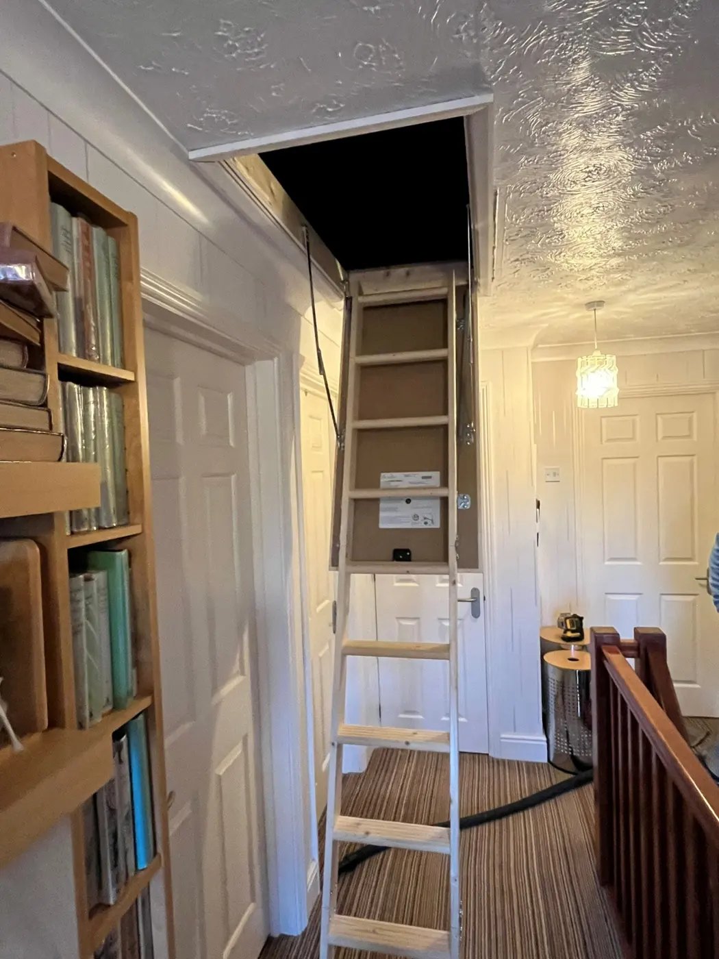 A loft ladder fitted in a hallway ceiling, opening to the loft above