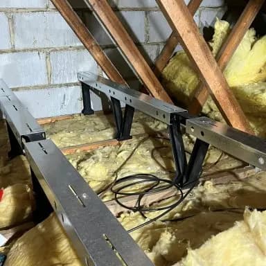 StoreFloor steel legs standing on the ceiling joists, with full-depth insulation beneath