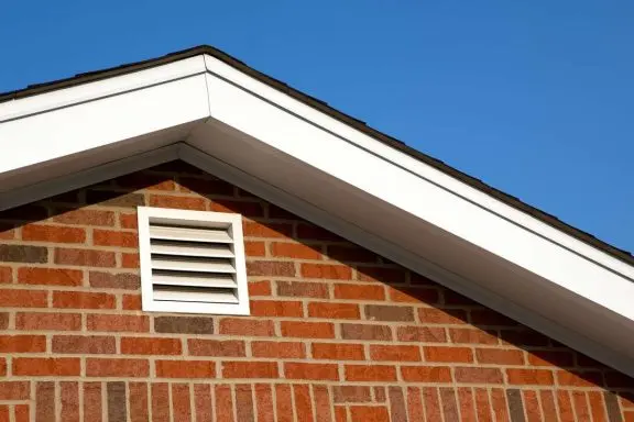 A gable end ventilation grille fitted in a brick wall